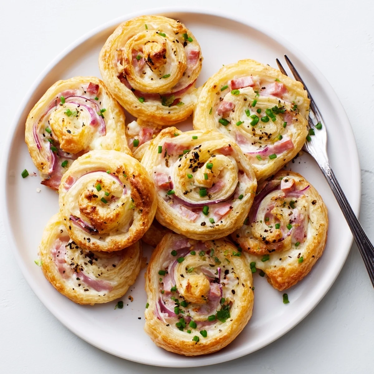 Würzige Ham and Cheese Pinwheels mit cremigem Käse und frischen Kräutern.  