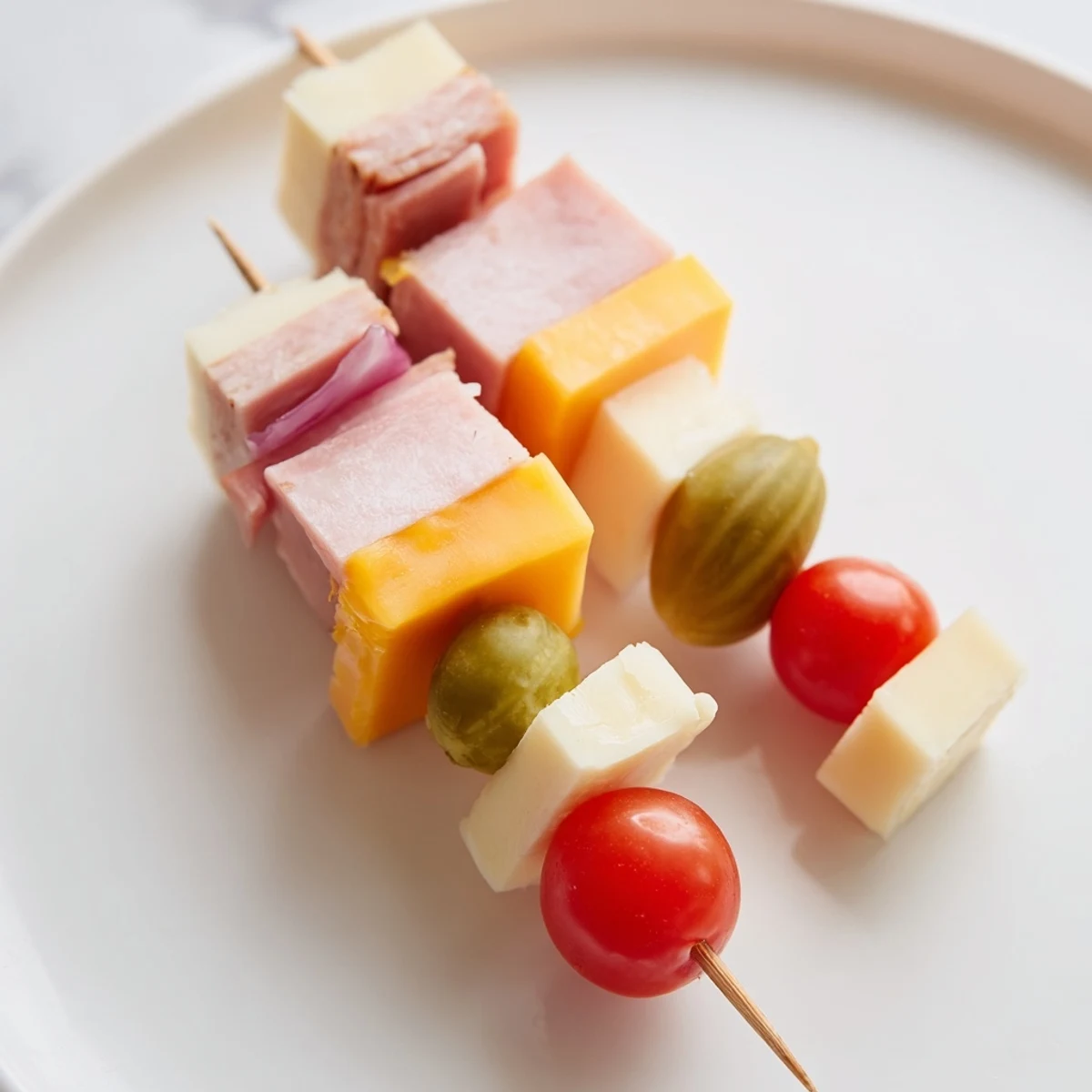 Savory Skewers showcasing vibrant meat, cheese, and pickle cubes ready to tantalize every taste bud.
