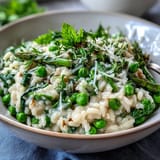 Ein leuchtend grünes, cremiges Risotto mit frischen Frühlingserbsen, Minze und Parmesan – ein leichtes, aber sättigendes Gericht.