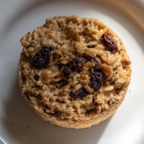 Golden baked oatmeal cups, pictured with fresh berries, perfect for a grab-and-go breakfast.