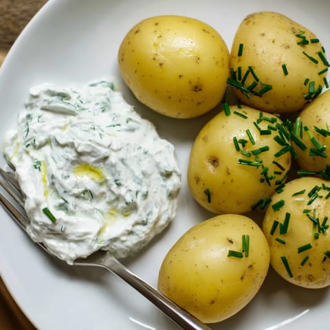 Gekochte Kartoffeln mit cremigem Quark-Dip, ideal für leichte Mahlzeiten oder Snacks.  