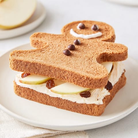 Gingerbread Man Sandwich cutouts, perfectly shaped sandwiches, decorated with apple slices and raisins.
