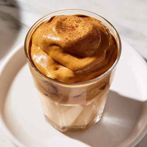 A close-up of a frothy Brown Sugar Dalgona Latte, ready to be enjoyed over ice.