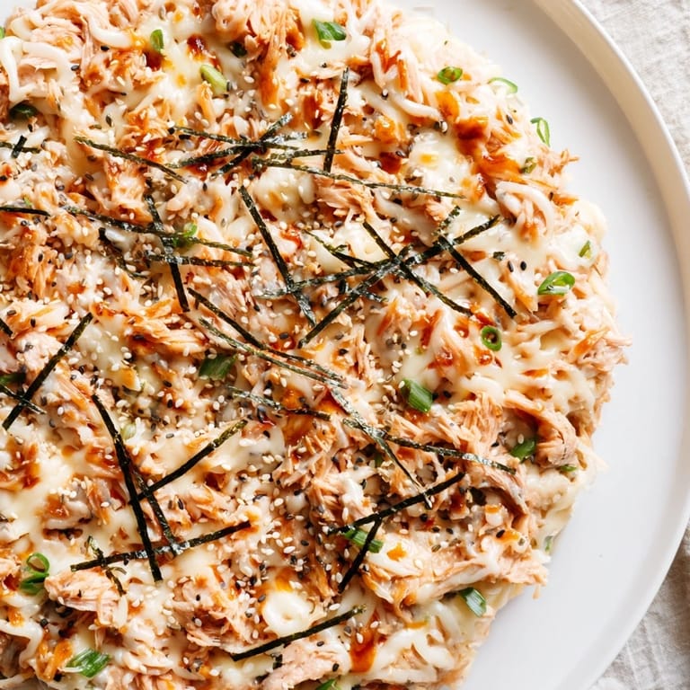 Golden and bubbly Creamy Salmon Sushi Bake in a baking dish, with sesame seeds and scallions as garnish.