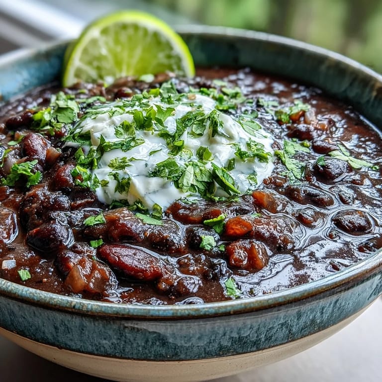 Warming Black Bean Soup simmered with spices, served hot with sour cream and crusty bread.